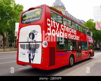 Rote Doppeldecker-Stadtrundfahrt 'Hop on / Hop off'-Bus, der an einer Haltestelle in der Königsallee in Düsseldorf/Deutschland wartet. Stockfoto