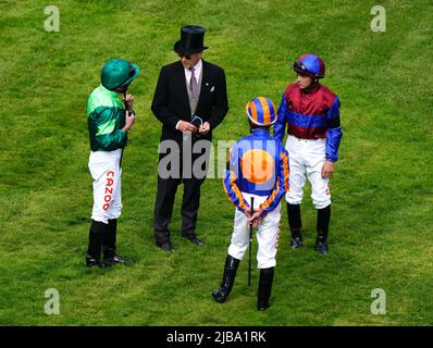 Trainer Aidan OÕBrien spricht mit seinem jockeyÕs Ryan Moore (links), Seamie Heffernan (Mitte) und Wayne Lordan vor dem Cazoo Derby am Derby Day während des Cazoo Derby Festivals 2022 auf der Epsom Racecourse, Surrey. Bilddatum: Samstag, 4. Juni 2022. Stockfoto