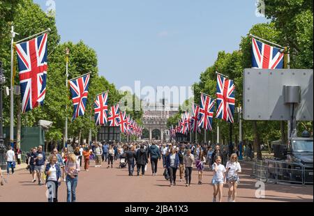 The Mall in London mit Menschen, die das Platin-Jubiläum der Königin an einem sonnigen Tag feiern, umgeben von Union Jack Flaggen. London - 4.. Juni 2022 Stockfoto