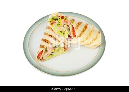 Zwei gegrillte Tortilla mit Speck, Salat und Tomaten umhüllt einen Teller, der gegen Weiß isoliert ist Stockfoto