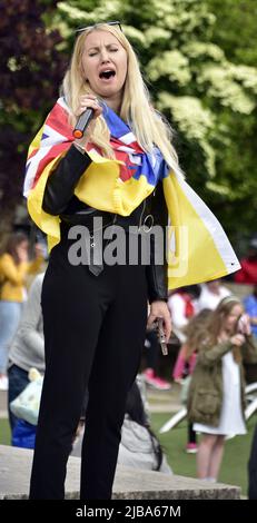 Manchester, Großbritannien, 4.. Juni 2022. Eine Protesterin singt ein ukrainisches Lied. Anti-Kriegs-Kundgebung „steht mit der Ukraine“, ein Protest gegen die russische Invasion der Ukraine in Piccadilly Gardens, im Zentrum von Manchester, England, Großbritannien und den Britischen Inseln. Dies ist der sechzehnte Samstag, an dem der Protest stattgefunden hat. Die Proteste werden vom Ukrainischen Kulturzentrum „Dnipro“ Manchester organisiert. Quelle: Terry Waller/Alamy Live News Stockfoto