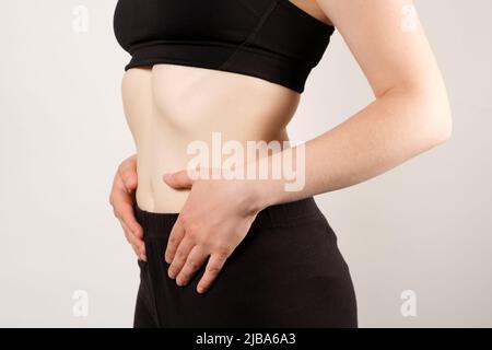 Nahaufnahme von Bauch und Taille einer Frau. Das Konzept der Gewichtsabnahme und Fitness Stockfoto