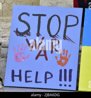 Manchester, Großbritannien, 4.. Juni 2022. Auf einem Plakat steht: 'Stoppt den Krieg. Hilfe.“. Anti-Kriegs-Kundgebung „steht mit der Ukraine“, ein Protest gegen die russische Invasion der Ukraine in Piccadilly Gardens, im Zentrum von Manchester, England, Großbritannien und den Britischen Inseln. Dies ist der sechzehnte Samstag, an dem der Protest stattgefunden hat. Die Proteste werden vom Ukrainischen Kulturzentrum „Dnipro“ Manchester organisiert. Quelle: Terry Waller/Alamy Live News Stockfoto