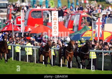 Midnights Legacy auf dem Weg zum World Pool Northern Dancer Handicap vor Haliphon und Royston Ffrench am Derby Day während des Cazoo Derby Festival 2022 auf der Epsom Racecourse, Surrey, geritten von Jockey William Buick (rechts). Bilddatum: Samstag, 4. Juni 2022. Stockfoto