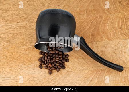 Türke für die Herstellung von Kaffee und Kaffeebohnen auf einem Holzbrett Stockfoto