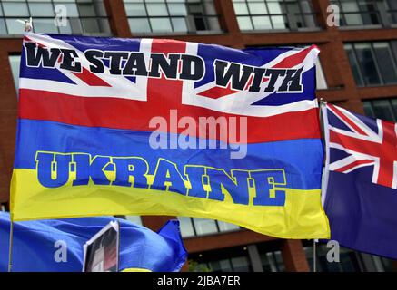 Manchester, Vereinigtes Königreich, 4. Juni 2022. Eine Flagge kombiniert die Farben des Union Jack und der ukrainischen Flagge mit einem „Wir stehen mit der Ukraine“-Text. "Stehen Sie mit der Ukraine zusammen", eine Demonstration gegen die russische Invasion der Ukraine in Piccadilly Gardens im Zentrum von Manchester, England, Vereinigtes Königreich, Britische Inseln. Dies ist der sechzehnte Samstag, an dem der Protest stattfand. Die Proteste werden vom Ukrainian Cultural Centre 'Dnipro' Manchester organisiert. Kredit: Terry Waller/Alamy Live News Stockfoto