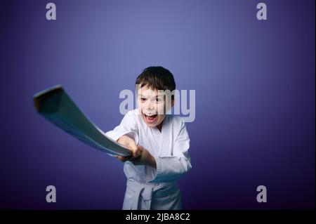 Porträt eines selbstbewussten starken europäischen Aikido-Kämpfers im Teenageralter mit traditionellem Samurai-Hakama-Kimono-Lernkampf mit Bambusschwert-Katana. Stockfoto