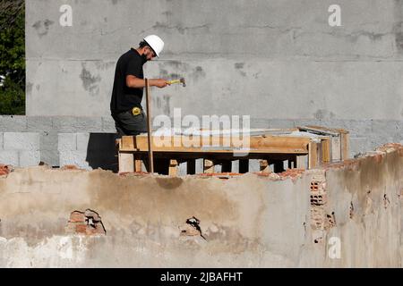 Zimmermann, Bauarbeiter. Arbeiter renovieren Dach des Gebäudes. Hausreparatur im Bau. Mann bei der Arbeit auf dem Dach Stockfoto