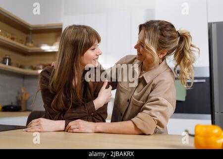 Schöne Erwachsene Tochter im Gespräch mit ihrer Mutter zu Hause Küche Stockfoto