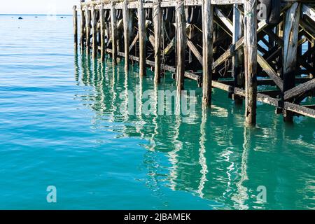 Strukturmuster und Reflexionen unter dem historischen Jackson Bay Pier, Südinsel Neuseeland. Stockfoto