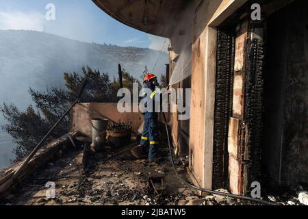 Athen, Griechenland. 4.. Juni 2022. Ein Feuerwehrmann kämpft am 4. Juni 2022 vor einem Haus in Voula, einem südlichen Vorort von Athen, Griechenland, gegen ein Feuer. Am Samstagnachmittag brach im südlichen Küstenabschnitt von Athen ein großes Waldbrand aus, der die Feuerwehr zu einer großen Reaktion veranlasste, als der Brand Wohngebiete erreichte. Quelle: Marios Lolos/Xinhua/Alamy Live News Stockfoto