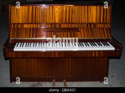 Vollskala, braunes Klavier, 88 Tasten, Tastatur. Weiße und schwarze Tasten in der Perspektive, zwei Pedale. Stockfoto
