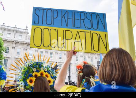 London, Großbritannien. 4.. Juni 2022. Ein Protestler hält ein Plakat mit dem Titel „Stop Cherson Occupation“. Demonstranten versammelten sich vor der Downing Street zum 33.. Jahrestag des Massakers auf dem Platz des Himmlischen Friedens an der Seite ukrainischer Demonstranten, um die Demokratie zu unterstützen, gegen die russische Invasion in der Ukraine, zum Gedenken an den Platz des Himmlischen Friedens und zur Unterstützung der Unabhängigkeit Hongkongs. Kredit: Vuk Valcic/Alamy Live Nachrichten Stockfoto