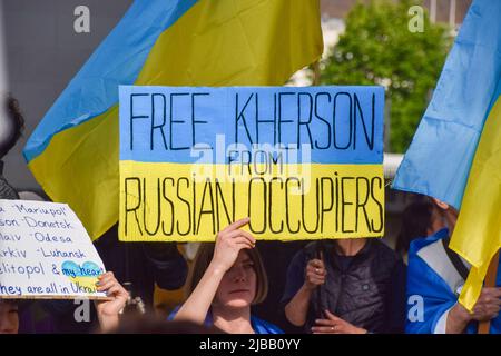 London, Großbritannien. 4.. Juni 2022. Ein Protestler hält ein Plakat mit dem Titel „Free Cherson“. Demonstranten versammelten sich vor der Downing Street zum 33.. Jahrestag des Massakers auf dem Platz des Himmlischen Friedens an der Seite ukrainischer Demonstranten, um die Demokratie zu unterstützen, gegen die russische Invasion in der Ukraine, zum Gedenken an den Platz des Himmlischen Friedens und zur Unterstützung der Unabhängigkeit Hongkongs. Kredit: Vuk Valcic/Alamy Live Nachrichten Stockfoto