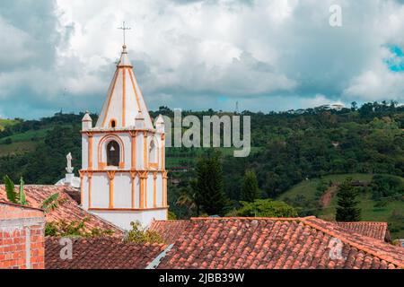 Turm der Kirche der Stadt Ocamonte in kolumbien mit Dächern und Berg im Hintergrund Stockfoto