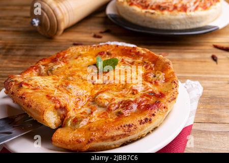 Chicago Style Deep Dish Cheese Pizza mit Tomatensauce, auf Holzhintergrund Stockfoto