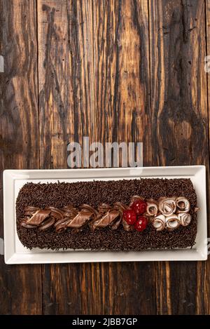 Eine köstliche Schweizer Rolle auf Holzboden Hintergrund. Biskuitkuchen. Brasilianisches Dessert. Rocambole-Kuchen Stockfoto