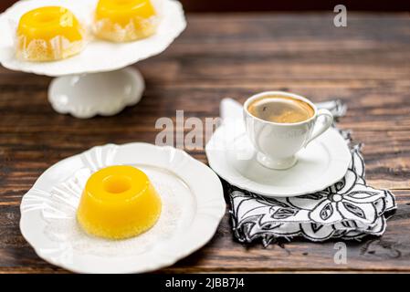 Ein brasilianisches Dessert aus Eiern und Kokosnuss. Quindim auf Holzhintergrund Stockfoto