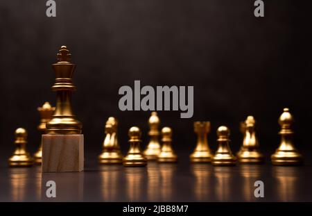 Goldener König Schach steht auf einem Holzständer. Das Konzept der Führungskräfte in guten Organisationen muss eine Vision haben und Geschäftstrends vorhersagen und assen können Stockfoto