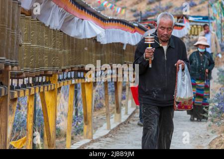 Shigatse, Tibet, China - 5. Juni 2022: Tibetische Pilger, die eine Kora durchführen (Umrundung im Uhrzeigersinn um einen heiligen Ort) Stockfoto