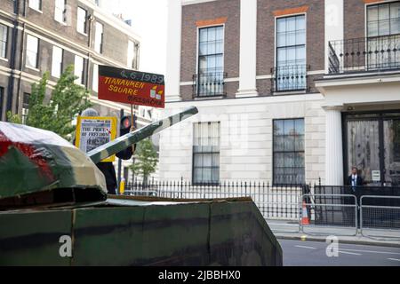 Während der Demonstration wird gegenüber der chinesischen Botschaft eine Tankkunstinstallation aus Pappe aufgestellt. Hongkongers, Tibeter und Uiguren veranstalten vor der chinesischen Botschaft in London eine Kerzenlichtmahnwache zum 33.. Jahrestag des Massakers auf dem Platz des Himmlischen Friedens. Am 4.. Juni 1989 schossen chinesische Truppen, bewaffnet mit Sturmgewehren und begleitet von Panzern, auf die studentischen Demonstranten und diejenigen, die versuchten, den Vormarsch des Militärs auf den Platz des Himmlischen Friedens zu blockieren. Bis heute bestreitet die chinesische Regierung immer noch, dass der Vorfall stattgefunden hat. Stockfoto