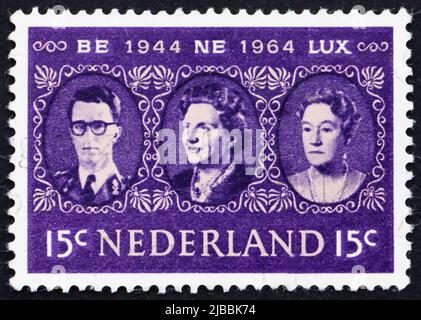 NIEDERLANDE - UM 1964: Eine in den Niederlanden gedruckte Briefmarke zeigt König Baudouin, Königin Juliana und Großherzogin Charlotte, Benelux, um 1964 Stockfoto