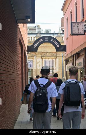 Zwei junge Männer und Menschen, die durch die Gasse gehen, begraben St. edmunds Stockfoto