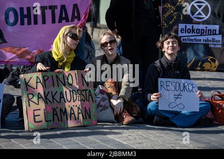 Kapinoin rakkaudesta elämään. Junge Frauen mit handgeschriebenen Schildern in Elokapina protestieren gegen den Überkonsum von Mannerheimintie in Helsinki, Finnland. Stockfoto