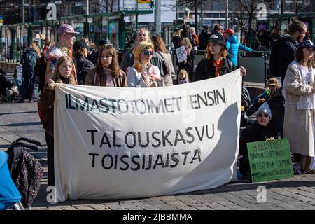 Ilmastotoimet ensin. Demonstranten hielten ein Banner und blockierten Mannerheimintie bei der Ylikulutuskapina-Demonstration von Elokapina in Helsinki, Finnland. Stockfoto
