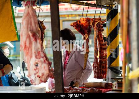 Frisches Fleisch hängt beim Fleischhändler in einem taiwanesischen Markt Stockfoto