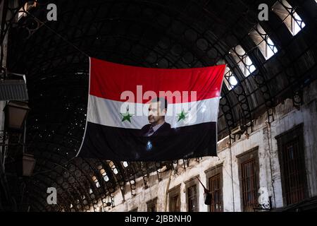 Damaskus, Syrien -Mai, 2022: Portraitbild von Baschar al-Assad, Präsident von Syrien auf syrischer Flagge in Suq Stockfoto