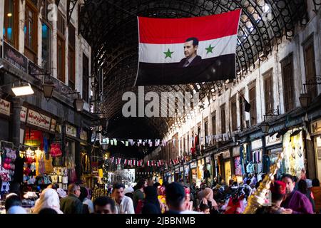 Damaskus, Syrien -Mai, 2022: Portraitbild von Baschar al-Assad, Präsident von Syrien auf syrischer Flagge bei Suq in Damaskus Stockfoto