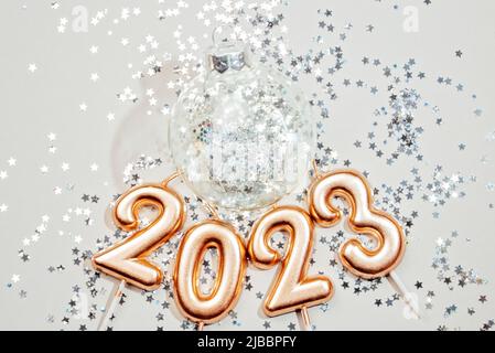 Urlaub Hintergrund Frohes neues Jahr 2023. Zahlen des Jahres 2023 von goldenen Kerzen auf Bokeh festlich funkelnden Hintergrund. Feiern Neujahr, Nahaufnahme. Platz für Text Stockfoto