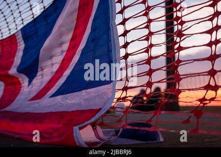 Union Flag und Plastiktrollzäune bei Sonnenuntergang Stockfoto