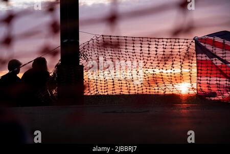 Union Flag und Plastiktrollzäune bei Sonnenuntergang Stockfoto