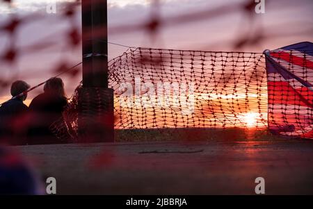 Union Flag und Plastiktrollzäune bei Sonnenuntergang Stockfoto