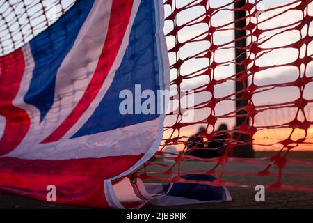 Union Flag und Plastiktrollzäune bei Sonnenuntergang Stockfoto