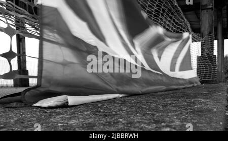 Union Flag und Plastikrollzäune im Sonnenuntergang Stockfoto