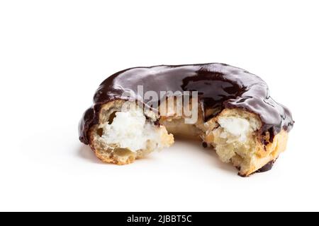 eclair in Form eines rings geformten, mit dunkler Schokolade überzogenen eclair, isoliert auf Weiß Stockfoto