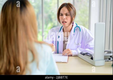 Konflikt zwischen Arzt und Patient am Schreibtisch im Krankenhaus Stockfoto