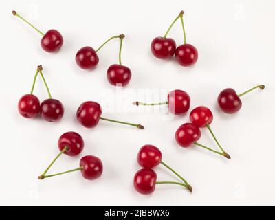 Frische rote Sauerkirschen isoliert auf weißem Hintergrund. Draufsicht. Flaches Lay-Muster Stockfoto
