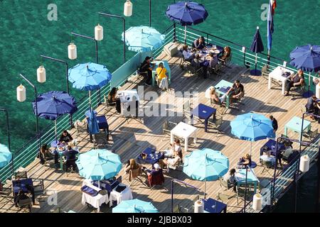 Sorrento, Italien - September 10 2021: Luftaufnahme von Menschen, die einen Drink in einem Strandclub in Sorrento in der Bucht von Neapel in Italien genießen. Stockfoto