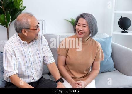 Ein glückliches Rentnerpaar, das sich zu Hause ansieht. Rentner, die sich zu Hause gegenseitig versorgen. Stockfoto