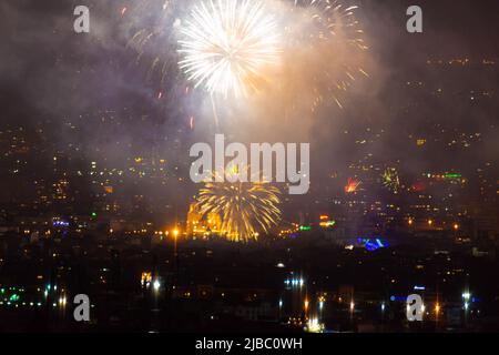 Blitze von hellen festlichen Feuerwerk auf dem schwarzen Himmel Hintergrund über dem Platz in der Silvesternacht in der Stadt Varna, Bulgarien Stockfoto