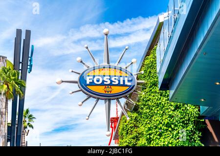 Fossile Geschäftszeichen oder Logo vor einem Einzelhandelsgeschäft.Universal Studios Florida ist ein berühmter Ort und eine wichtige Touristenattraktion im südlichen Bundesstaat. Stockfoto