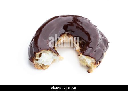 eclair in Form eines rings geformten, mit dunkler Schokolade überzogenen eclair, isoliert auf Weiß Stockfoto