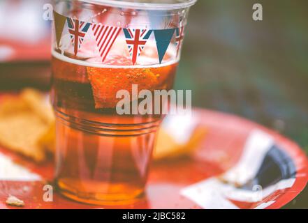 Mit Bunting überdachtes Bierglas und Teller beim Picknick am Nachmittag bei den Feierlichkeiten zum Platin-Jubiläum der Königin im Garth Park, Bicester. Stockfoto