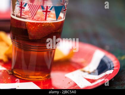 Mit Bunting überdachtes Bierglas und Teller beim Picknick am Nachmittag bei den Feierlichkeiten zum Platin-Jubiläum der Königin im Garth Park, Bicester. Stockfoto