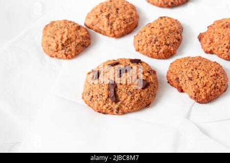 Hausgemachte Haferkekse mit Schokolade auf weißem Hintergrund. Rustikaler Snack für einen gesunden Lebensstil. Stockfoto