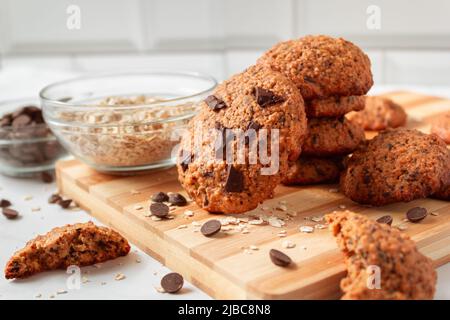 Nahaufnahme von köstlichen hausgemachten Haferkeksen mit Schokolade. Gesundes Frühstück auf Holzbrett. Rustikaler Snack für einen gesunden Lebensstil. Stockfoto